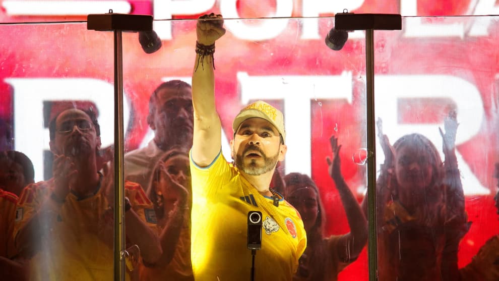Abelardo de la Espriella en tarima con el puño en alto ante una pantalla roja
